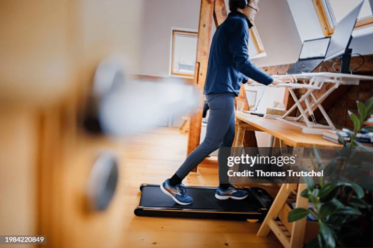 Woman working at a standing desk, a great tool for doing desk exercises.