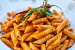 tasty. Savor the flavors of Italian cuisine with this close-up photo of tasty penne pasta in tomato sauce.