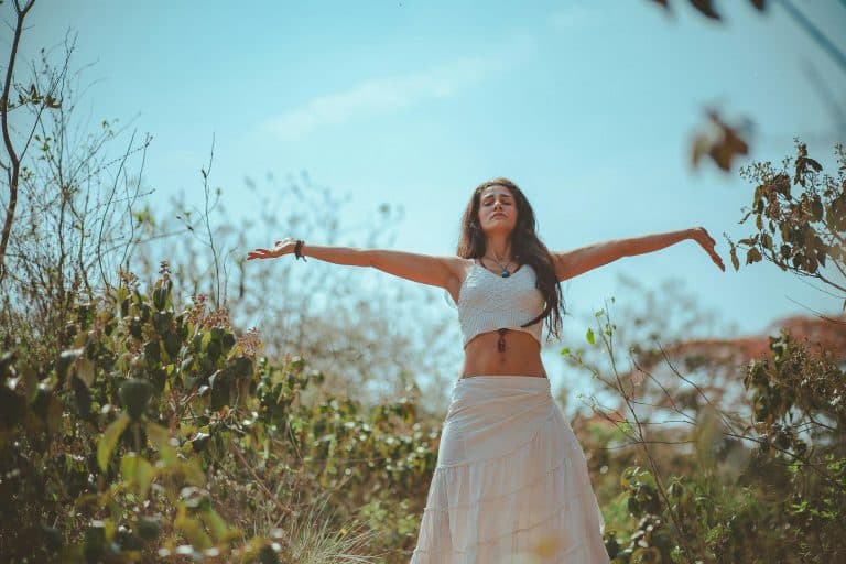 Peaceful scene of a woman meditating outdoors in a sunny summer setting, embodying wellness and tranquility. wellness podcasts