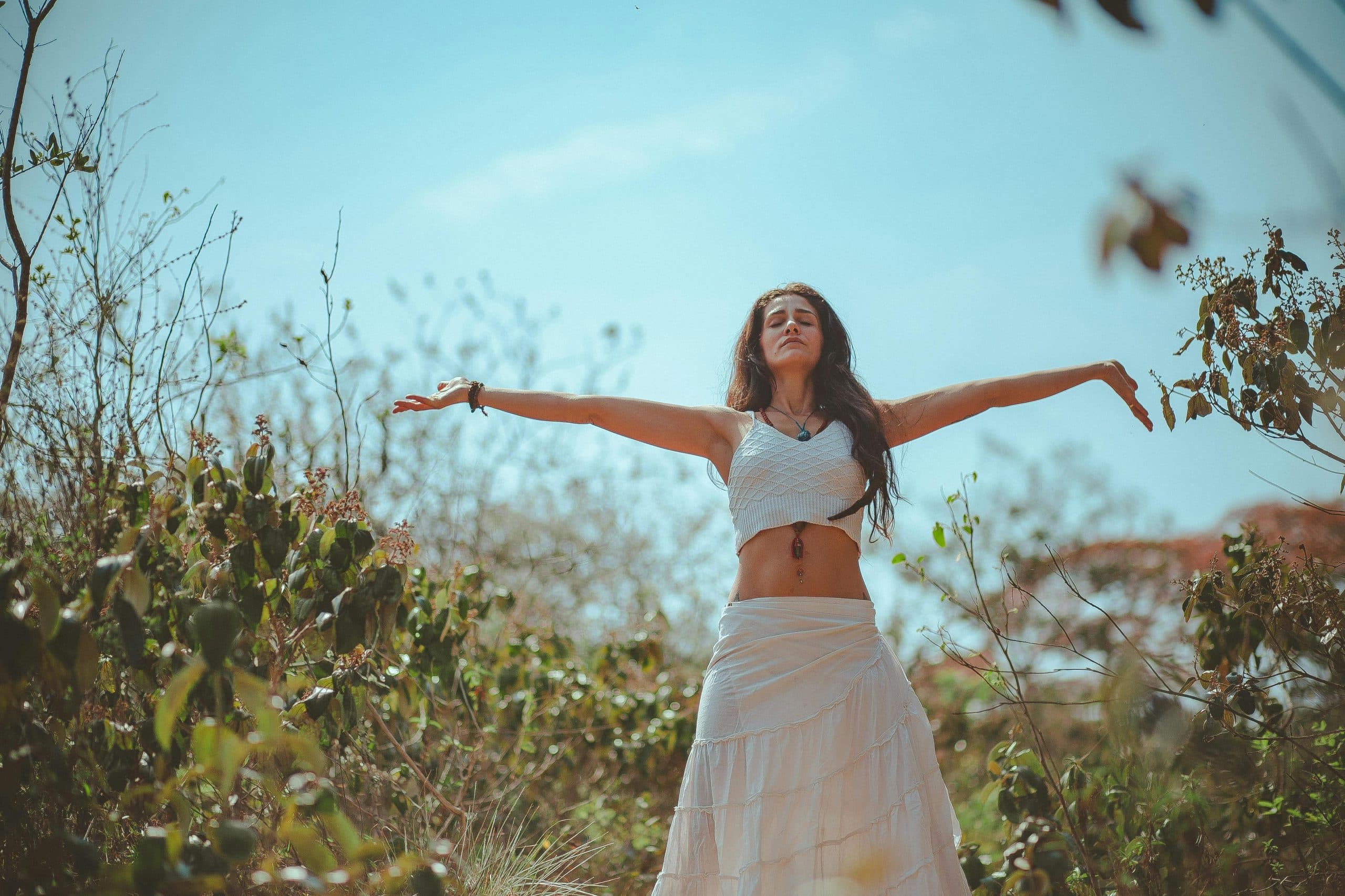 Peaceful scene of a woman meditating outdoors in a sunny summer setting, embodying wellness and tranquility. wellness podcasts