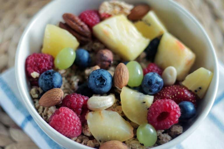 Close-up of a colorful muesli bowl with fresh berries, nuts, and pineapple. Contains superfoods