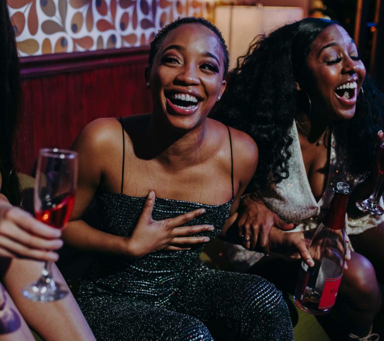 Joyful moment among friends enjoying drinks and laughter at a festive indoor party. love bombing friendships