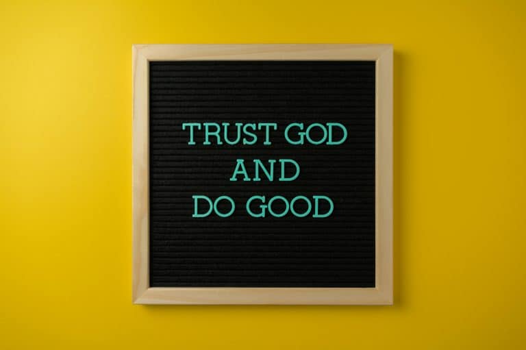 Inspirational message 'Trust God and Do Good' on a stylish black letter board with a vibrant yellow background. Proverbs 3