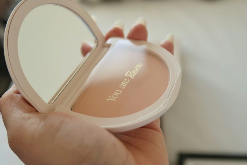 This photograph is of a compact. "You are Rare" is written inside." Rare Beauty is a makeup company begun by Selena Gomez.