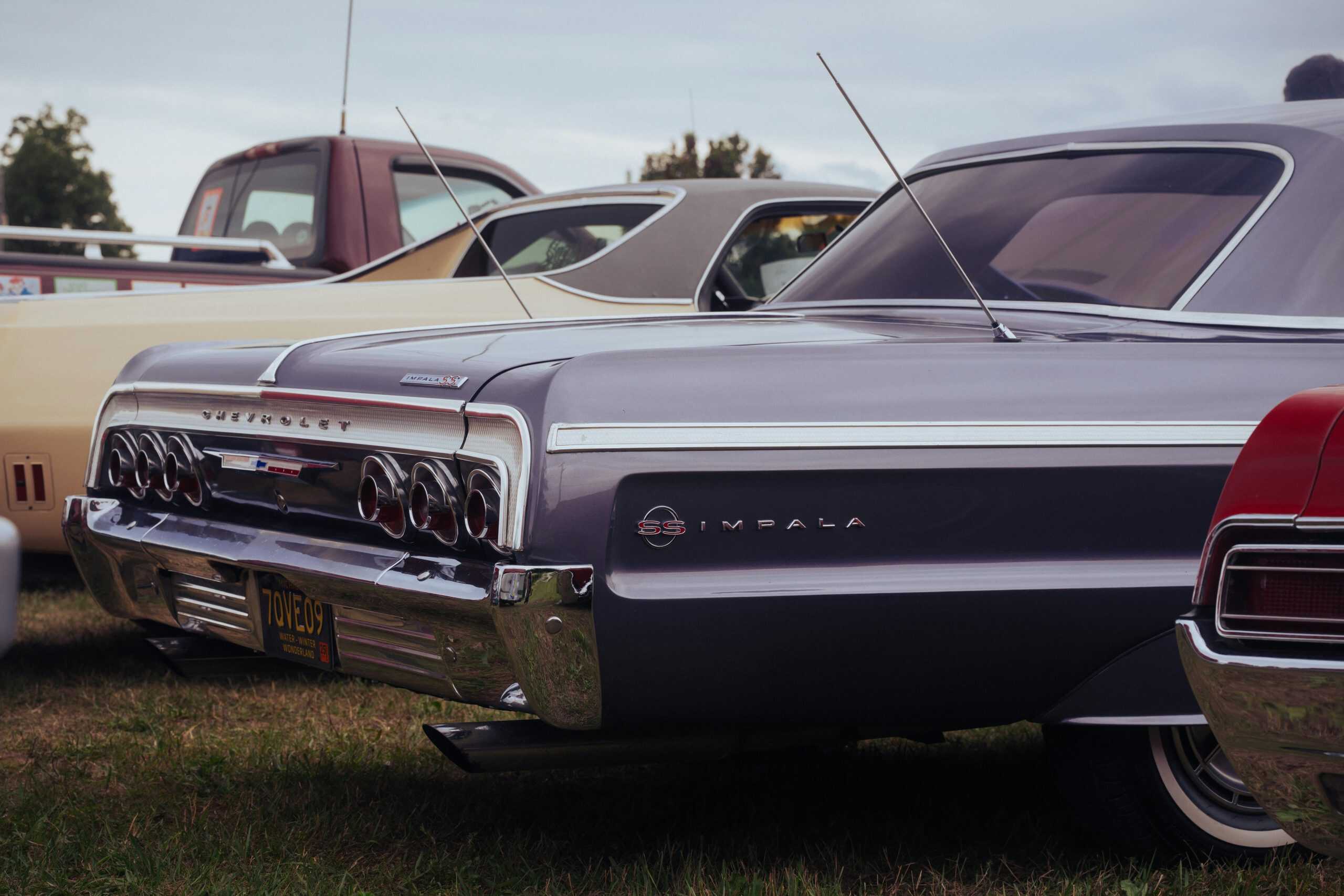 Classic Chevrolet Impala on display at an outdoor car show, showcasing vintage automotive design. Chevy Impala