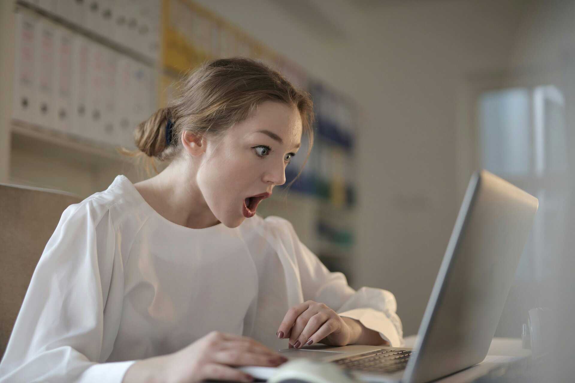 This photograph features a woman looking at her laptop in surprise. Shared digital calendars can keep scheduling surprises at a minimum.