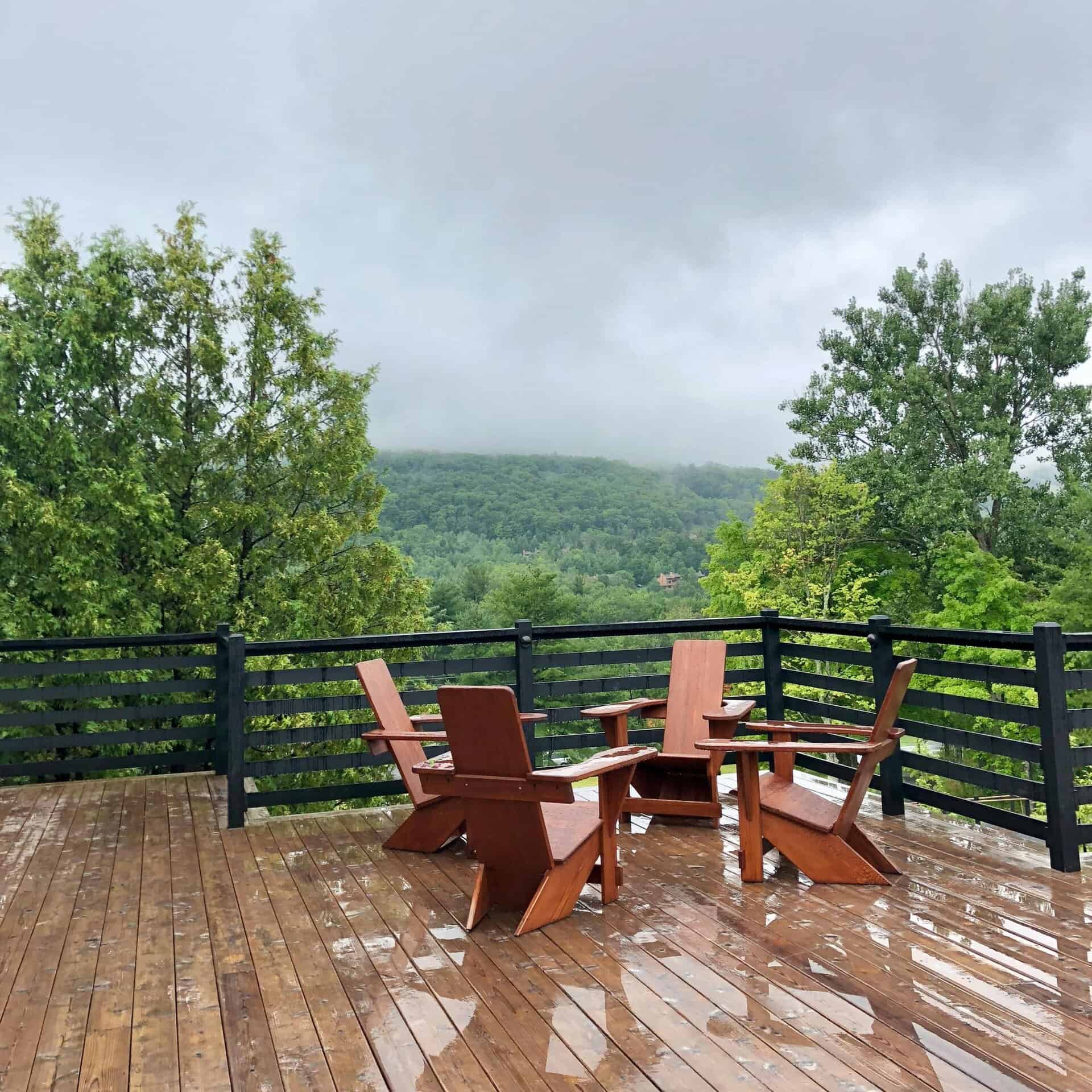 Wooden deck with chairs offering a serene mountain view, perfect for relaxation.